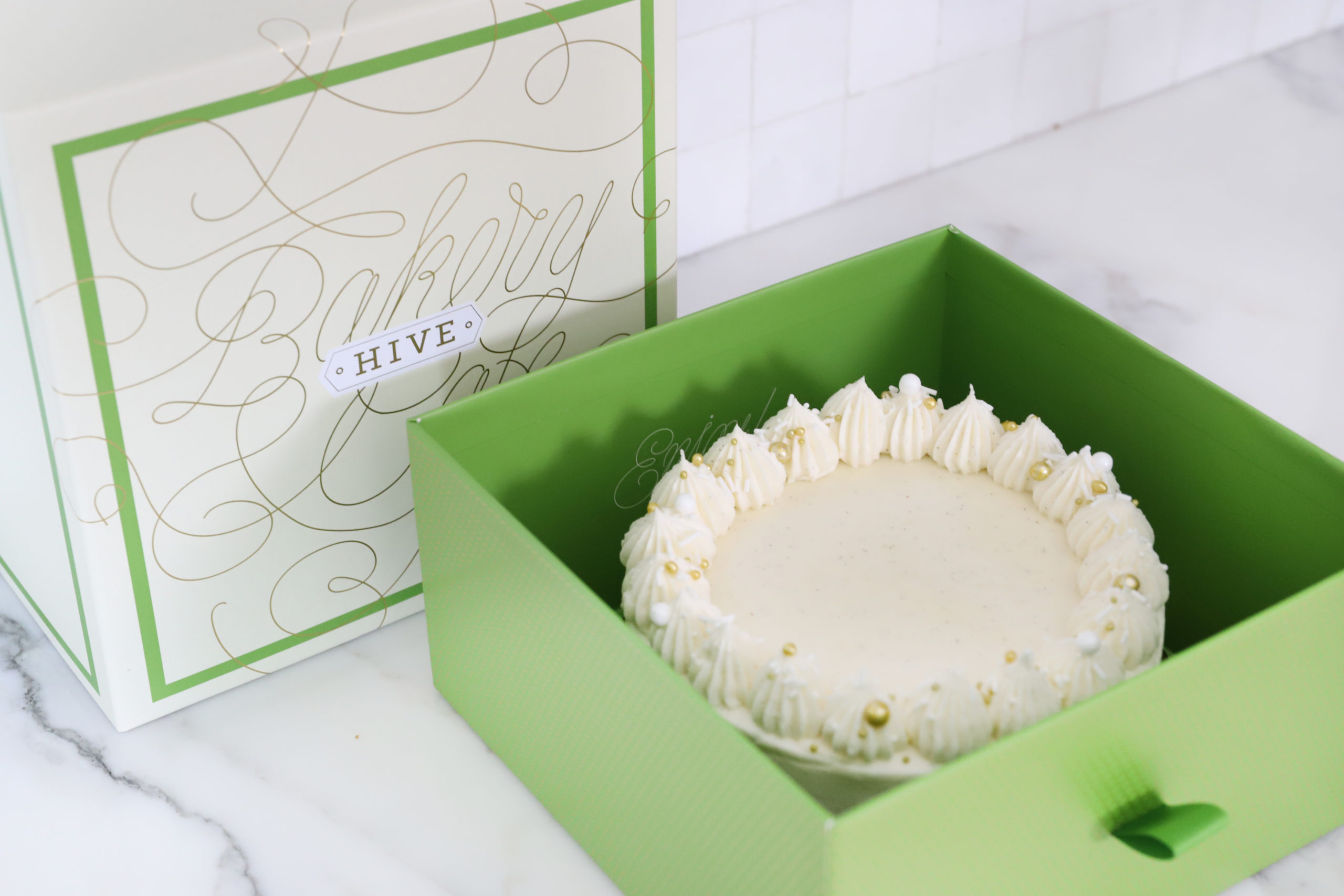 image of white cake in hive pastry box