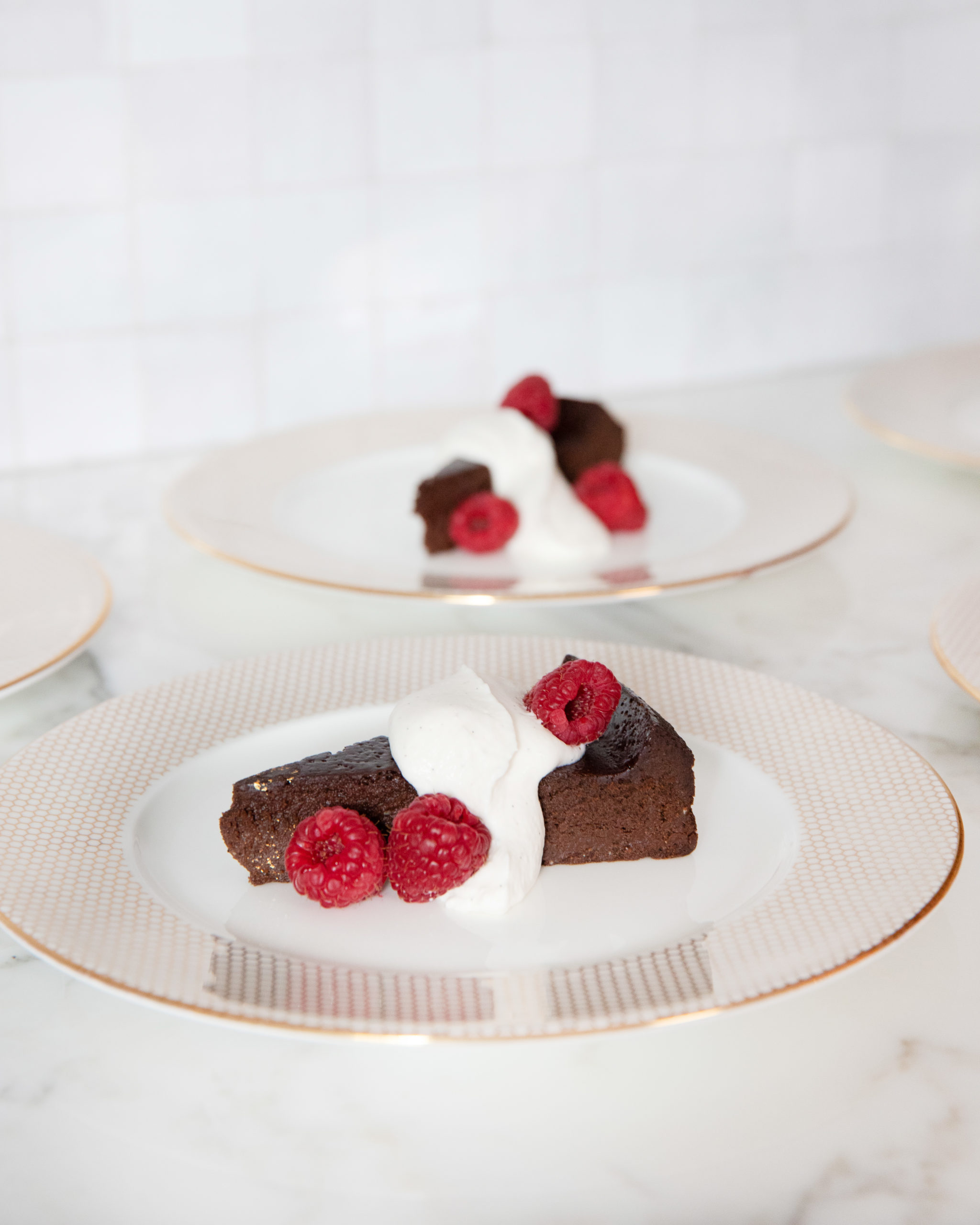 image of flourless chocolate cake plated with raspberries
