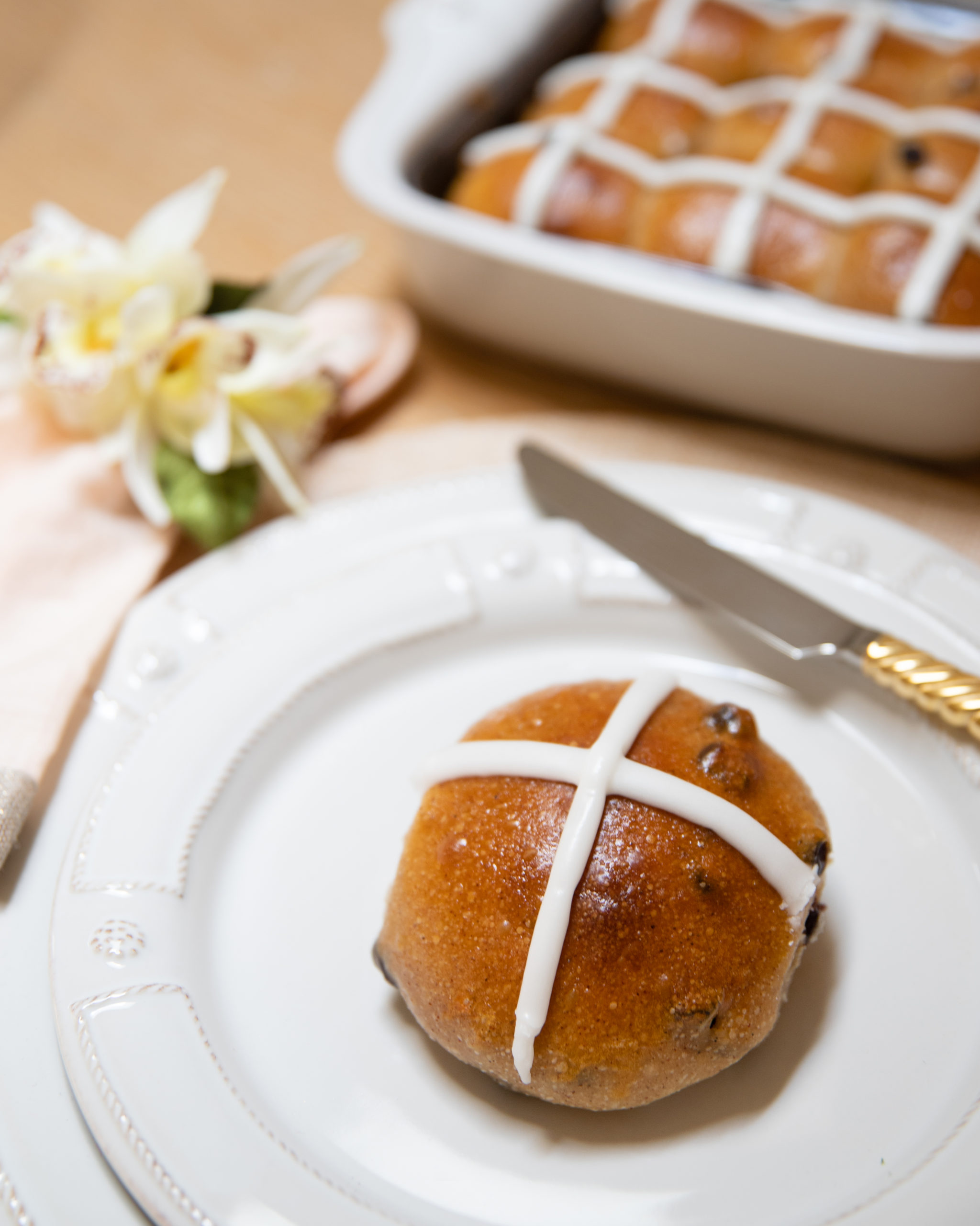 image of frosted hot cross bun on plate