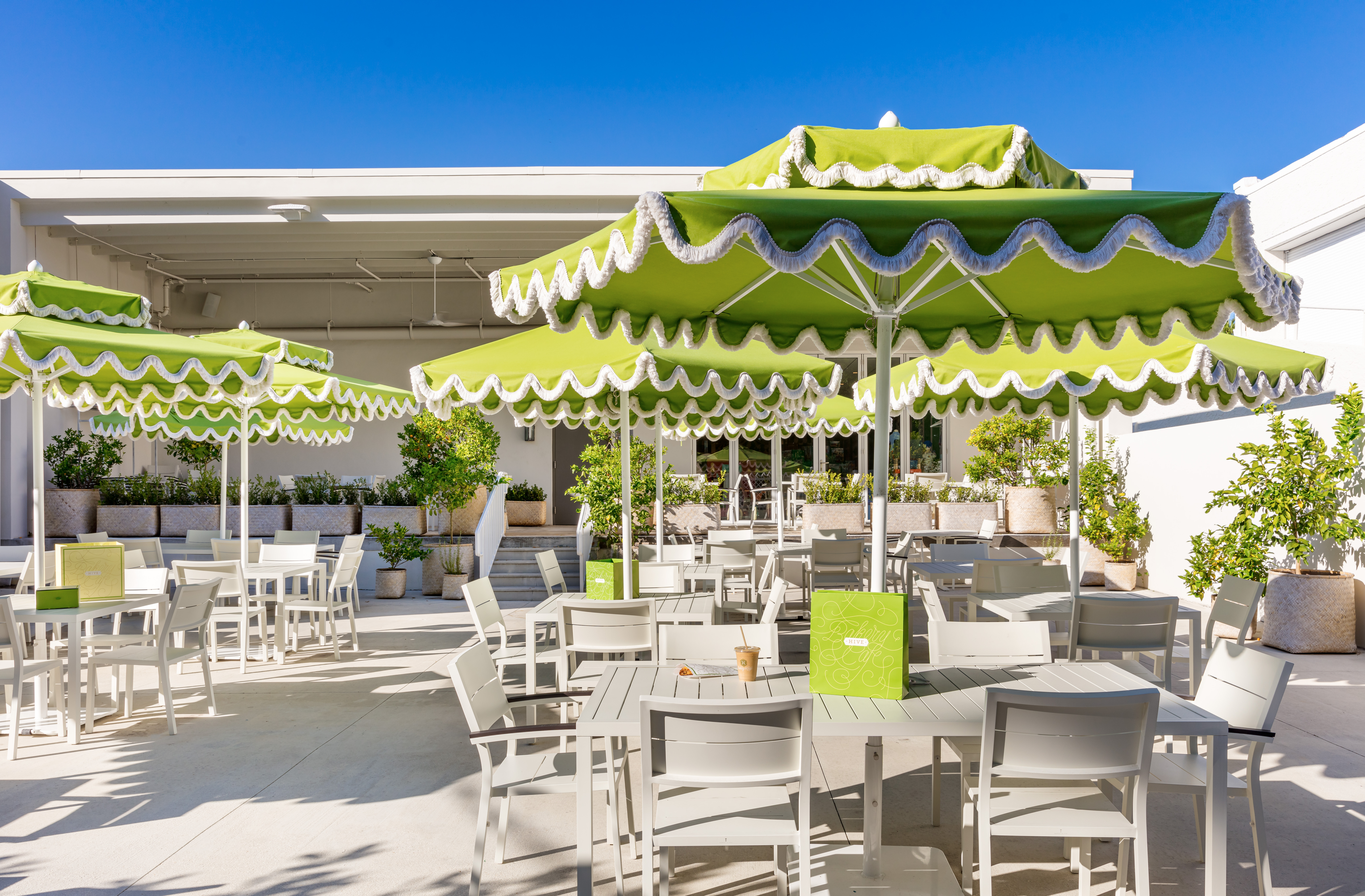 Photo of Hive's Outdoor Garden area with tables and green umbrellas